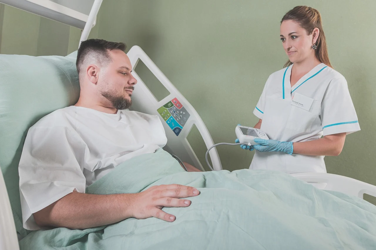 A patient in bed, nurse by their side.