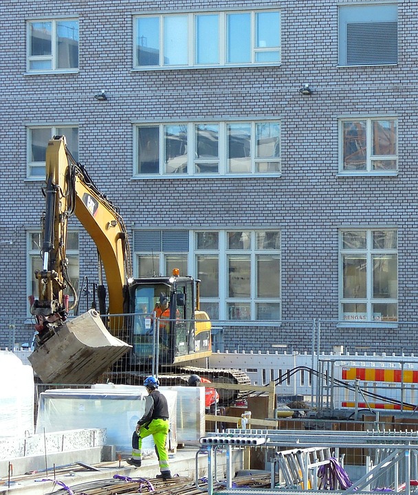 Construction workers operate heavy machinery at a busy site