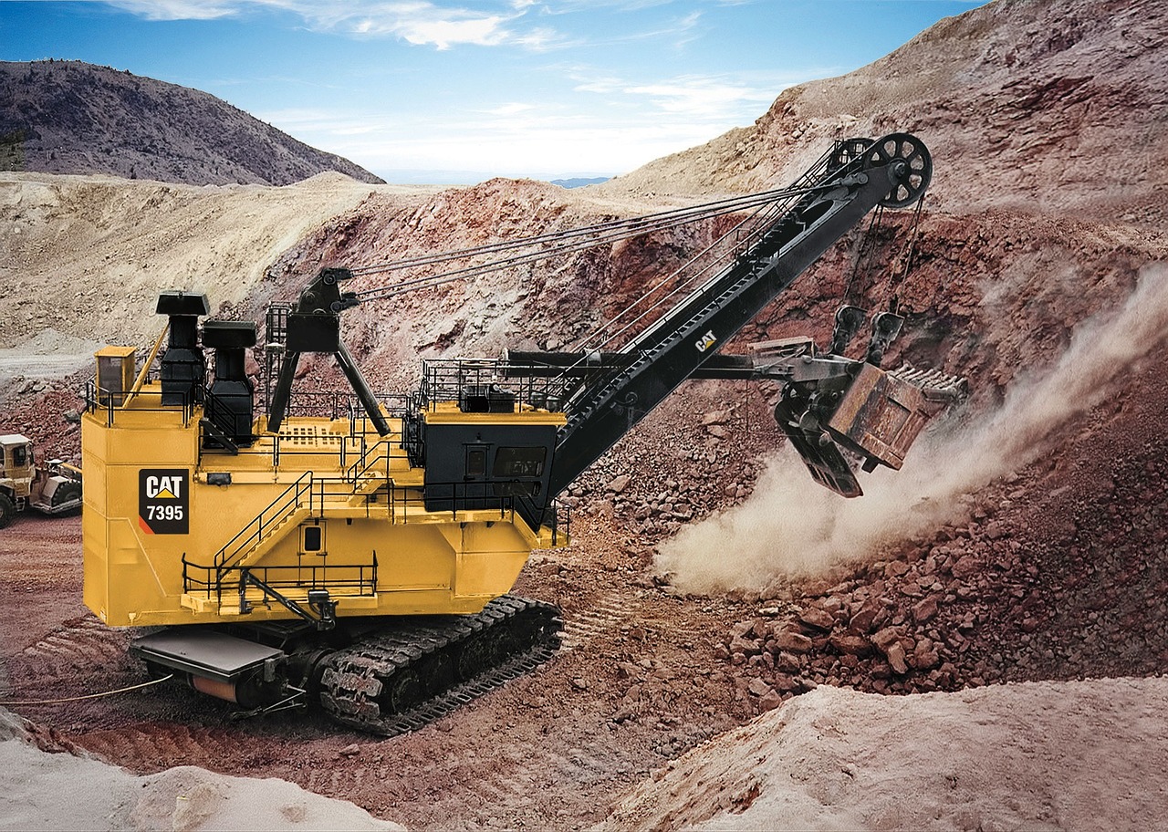 Heavy excavator machinery digs and moves earth at a construction excavation site