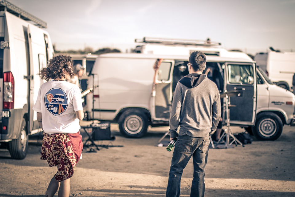 Band members loading music equipment into a rental van.