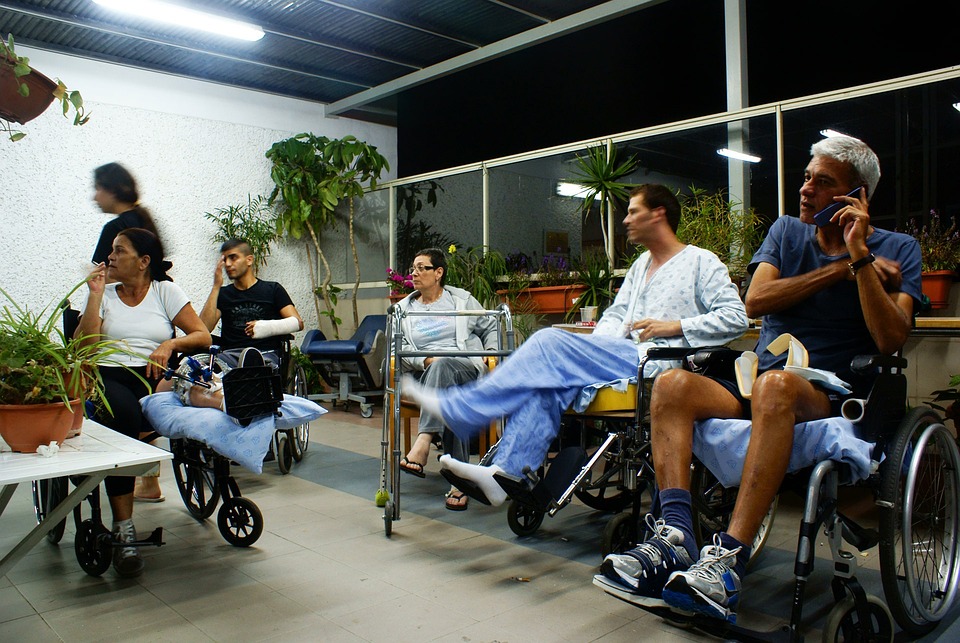 Patients in wheelchairs wait to receive care and therapy at a healthcare facility.