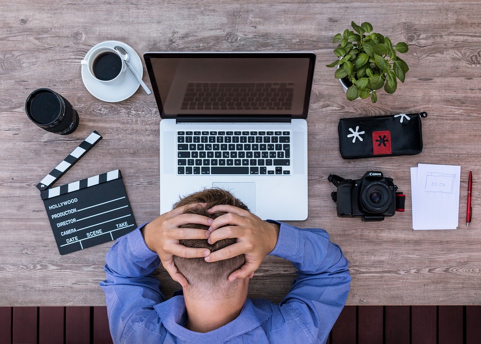 Media production professional with hands on head, looking frustrated and overwhelmed.