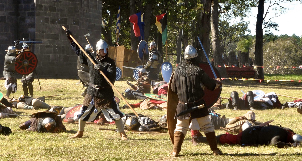 Two knights in armor engage in a dramatic medieval reenactment battle