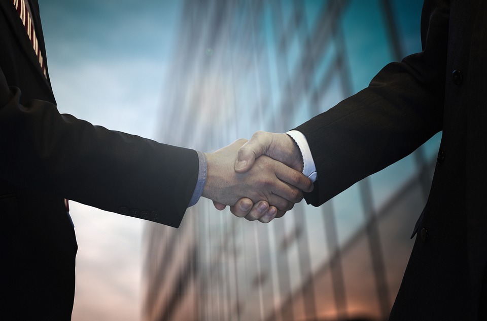 Business partners shaking hands, sealing a successful merger and new partnership.