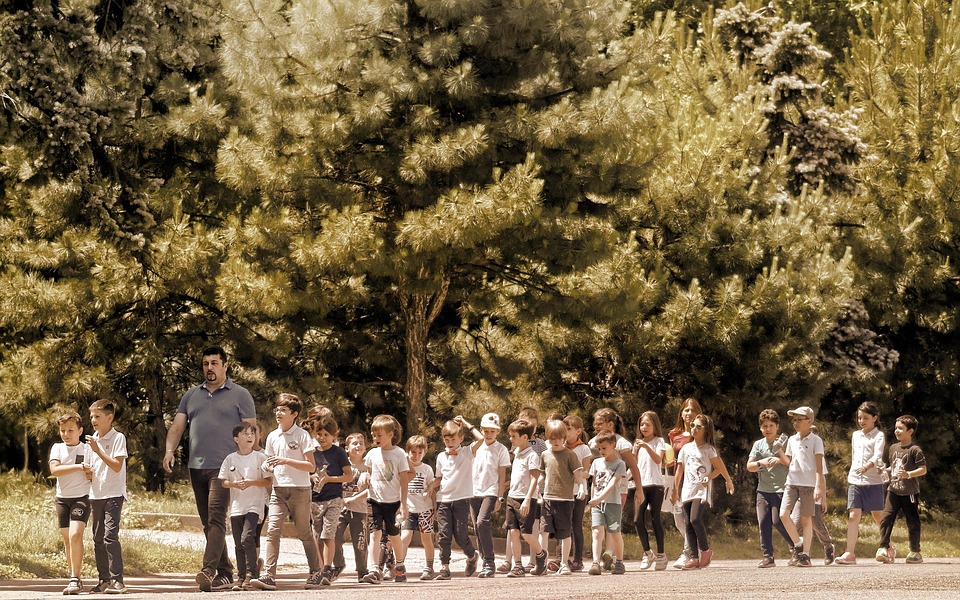 Montessori teacher takes students on outdoor learning adventure.