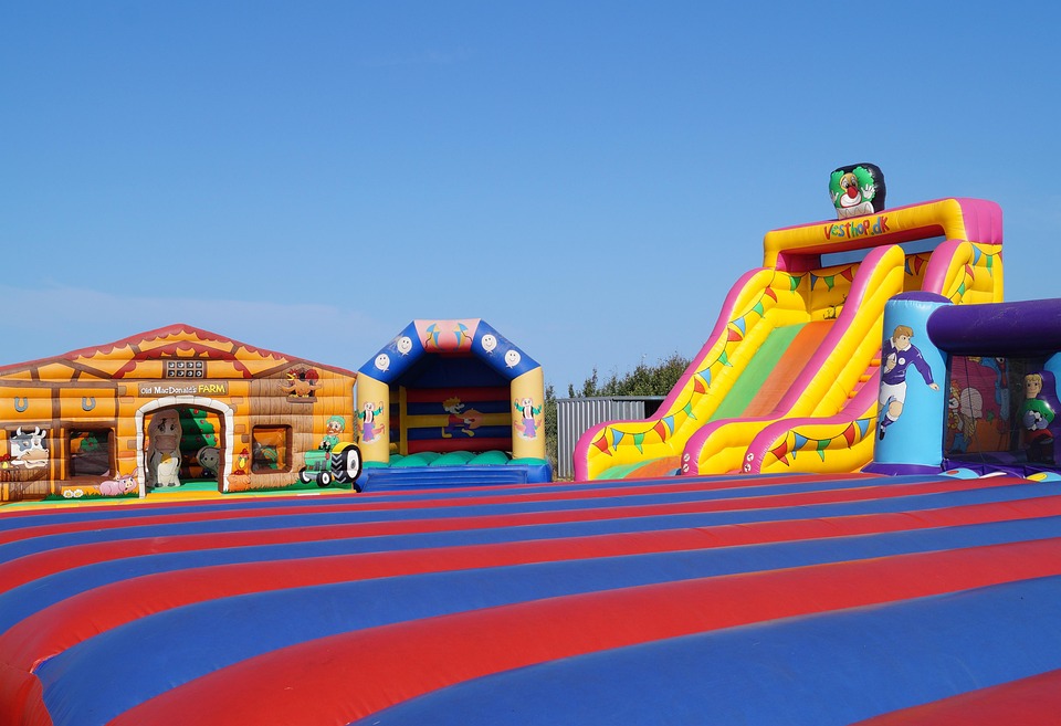 Colorful inflated moon bounces and slides at a bustling carnival