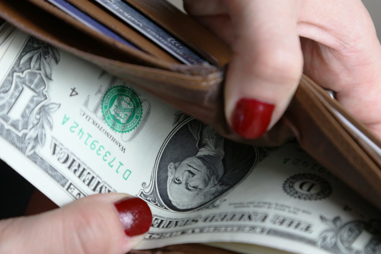 Cash is taken out of a wallet.