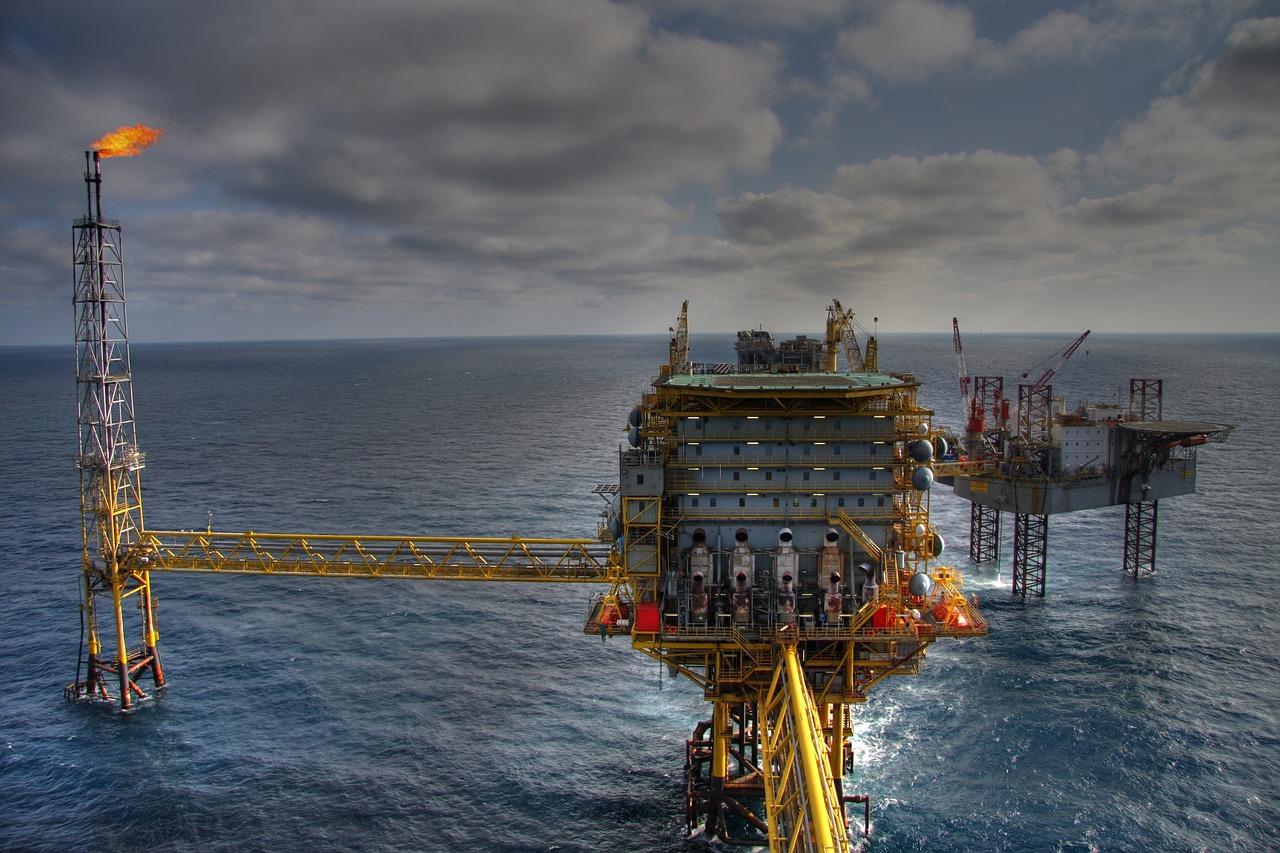Oil rig at sea: Drilling platform illuminated against an ocean backdrop.