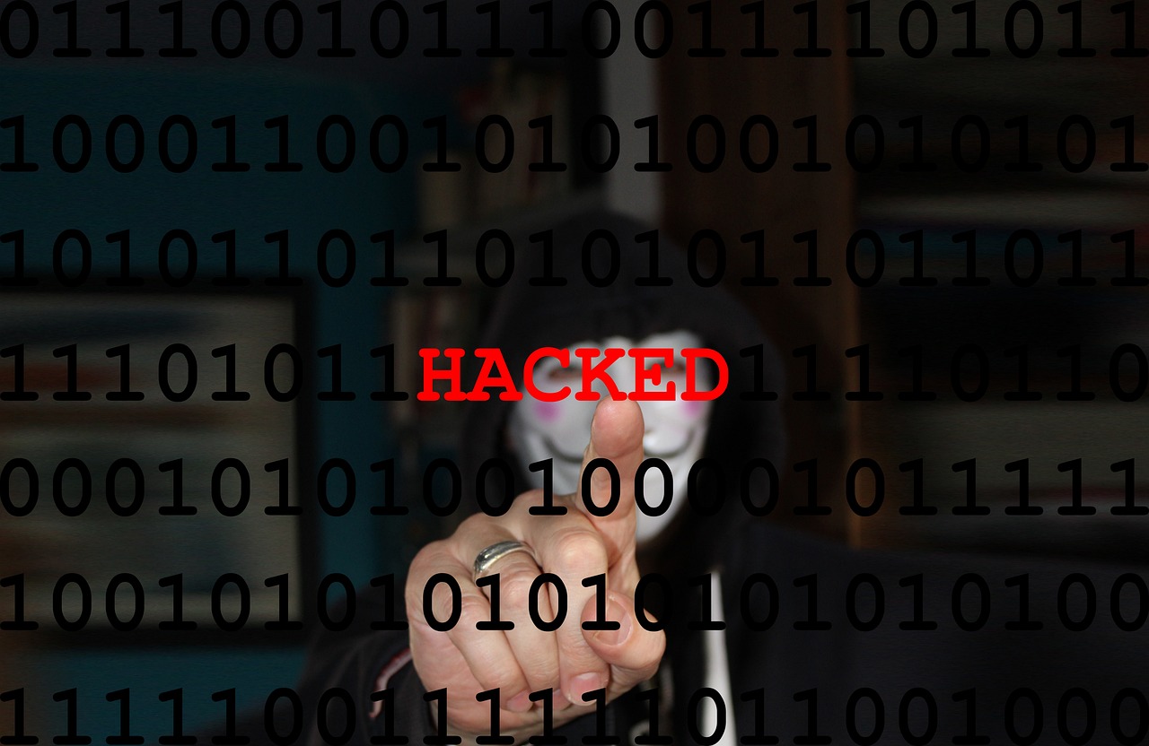 Hacker on screen with 'Hacked' text warning