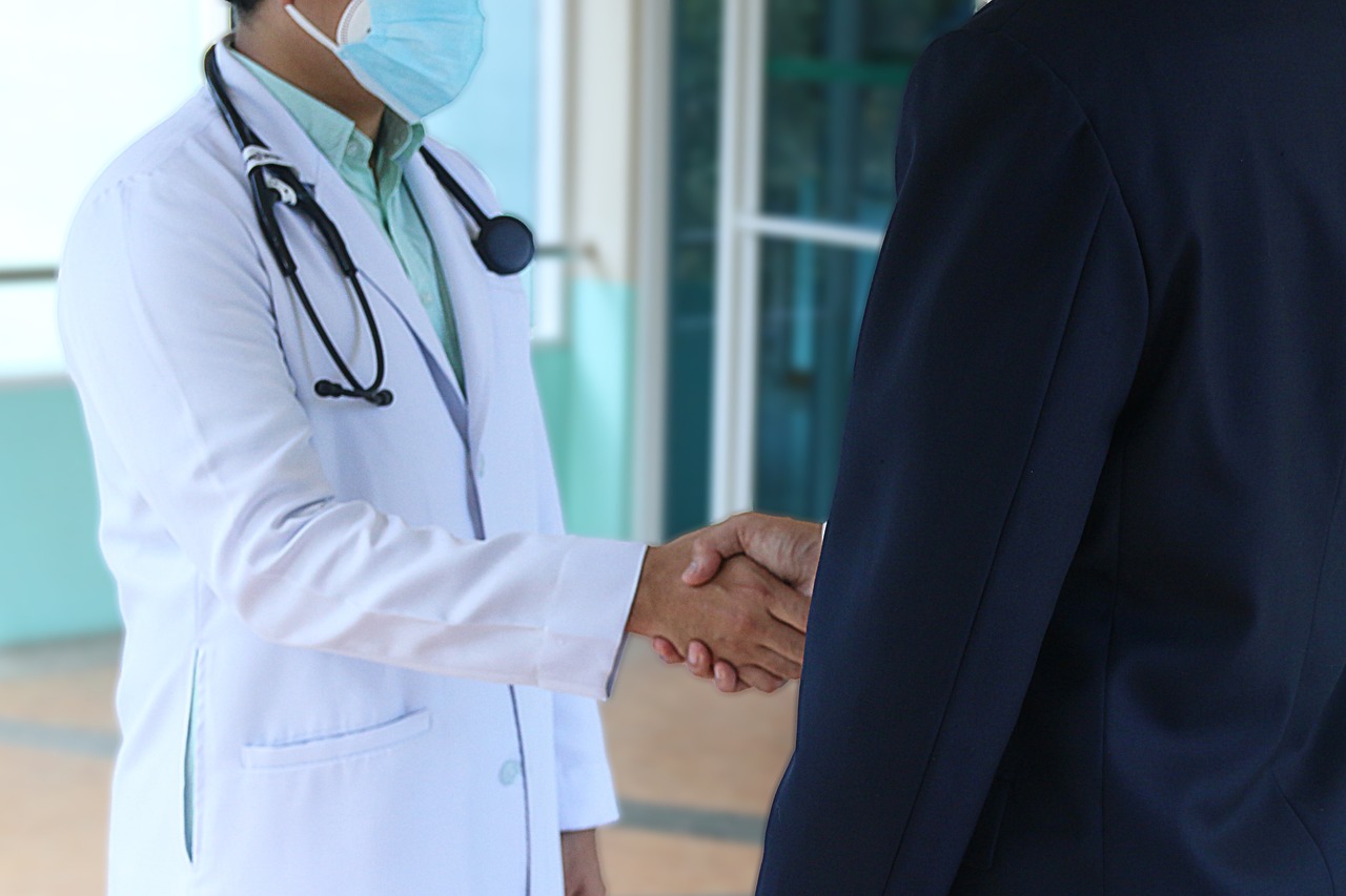 Physician shakes hands with insurance agent after securing specialized Professional Liability Insurance.