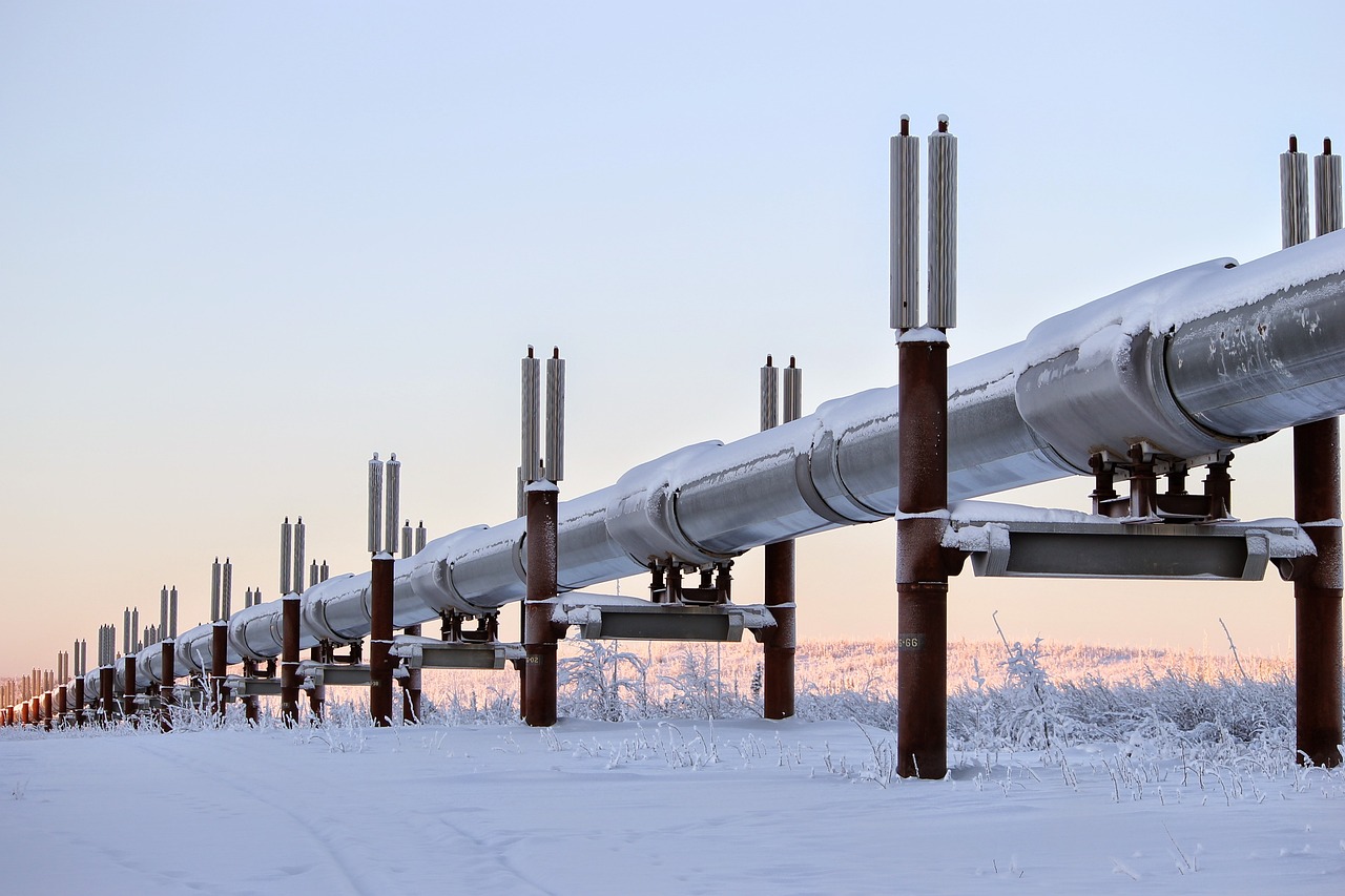 Oil pipeline stretches across a snowy landscape.
