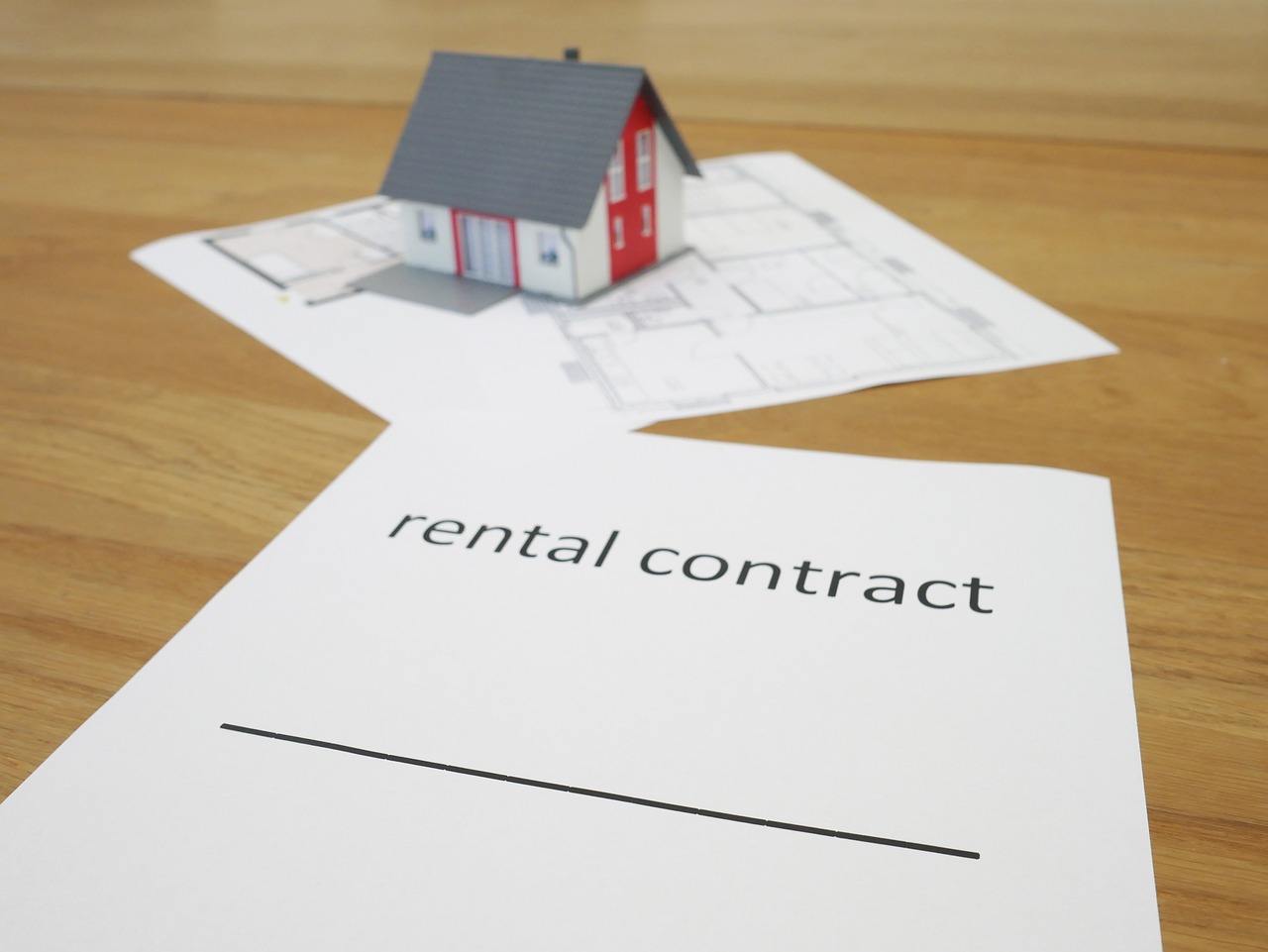 Rental contract in focus with a house in the background,