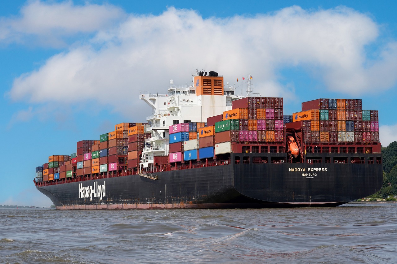 Cargo vessel with stacked containers, sailing through calm waters