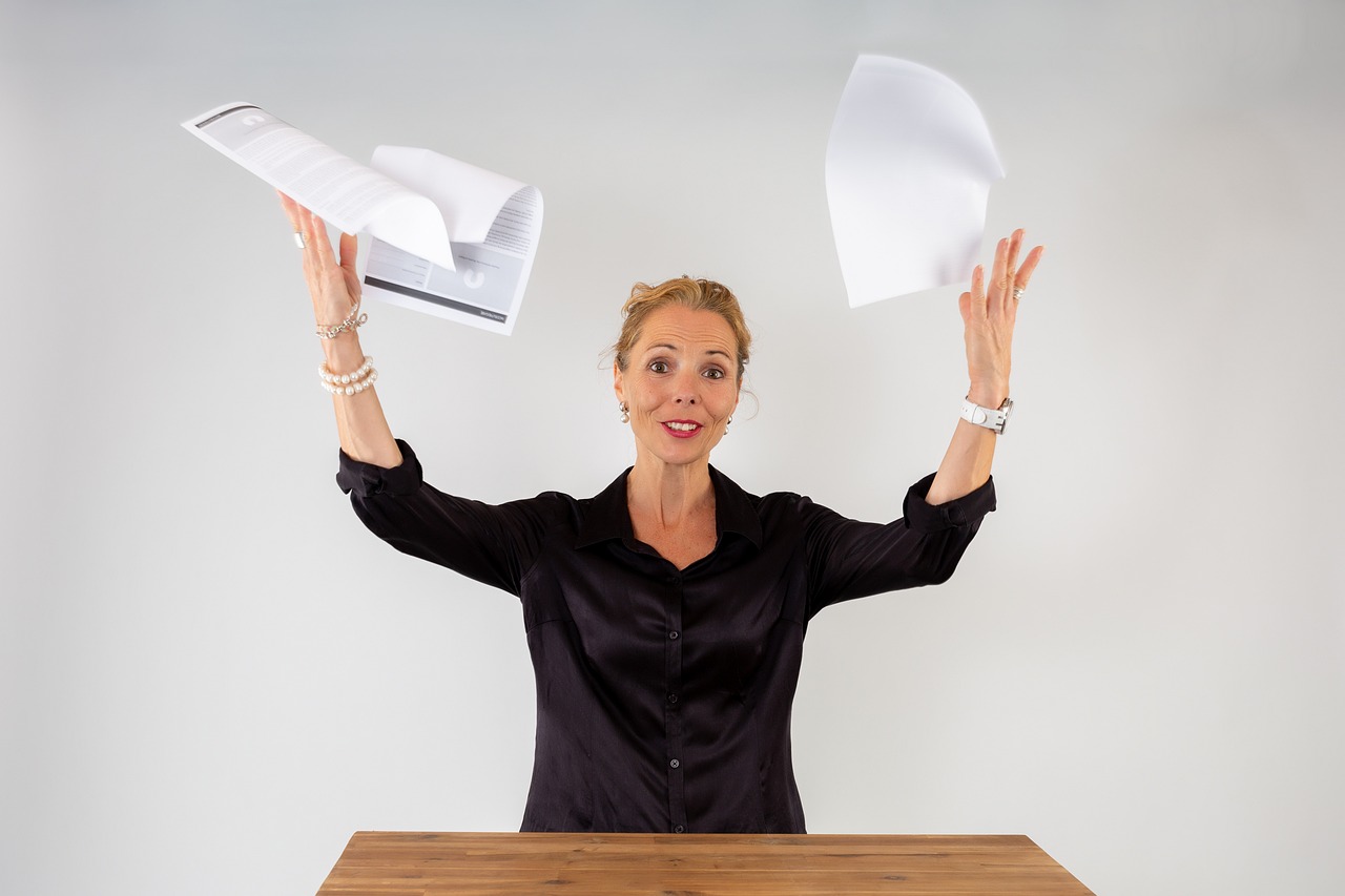 Real estate broker at wit's end, tossing documents in frustration.