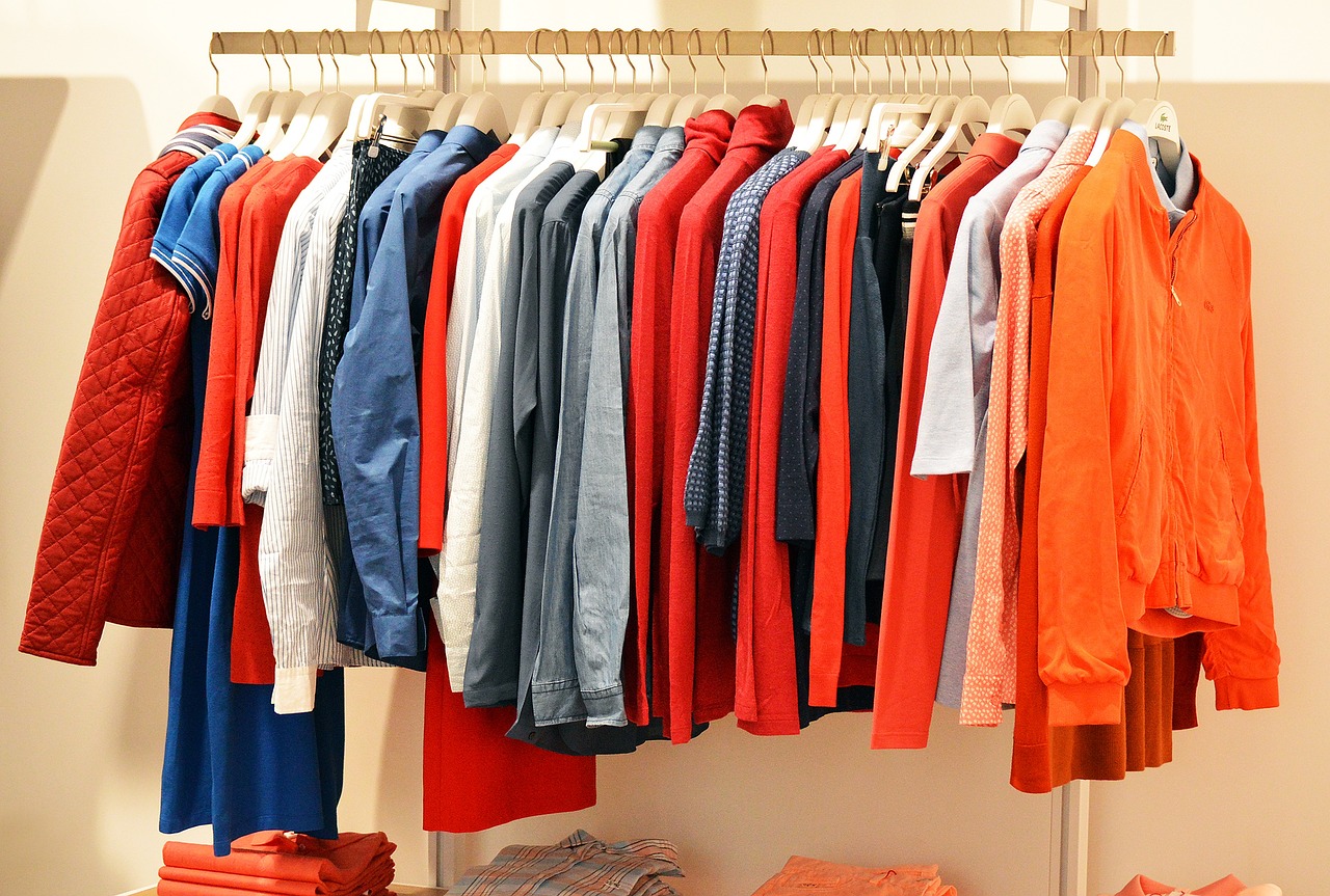 Garments hanging on racks at a dry cleaning establishment, awaiting cleaning and pressing services.