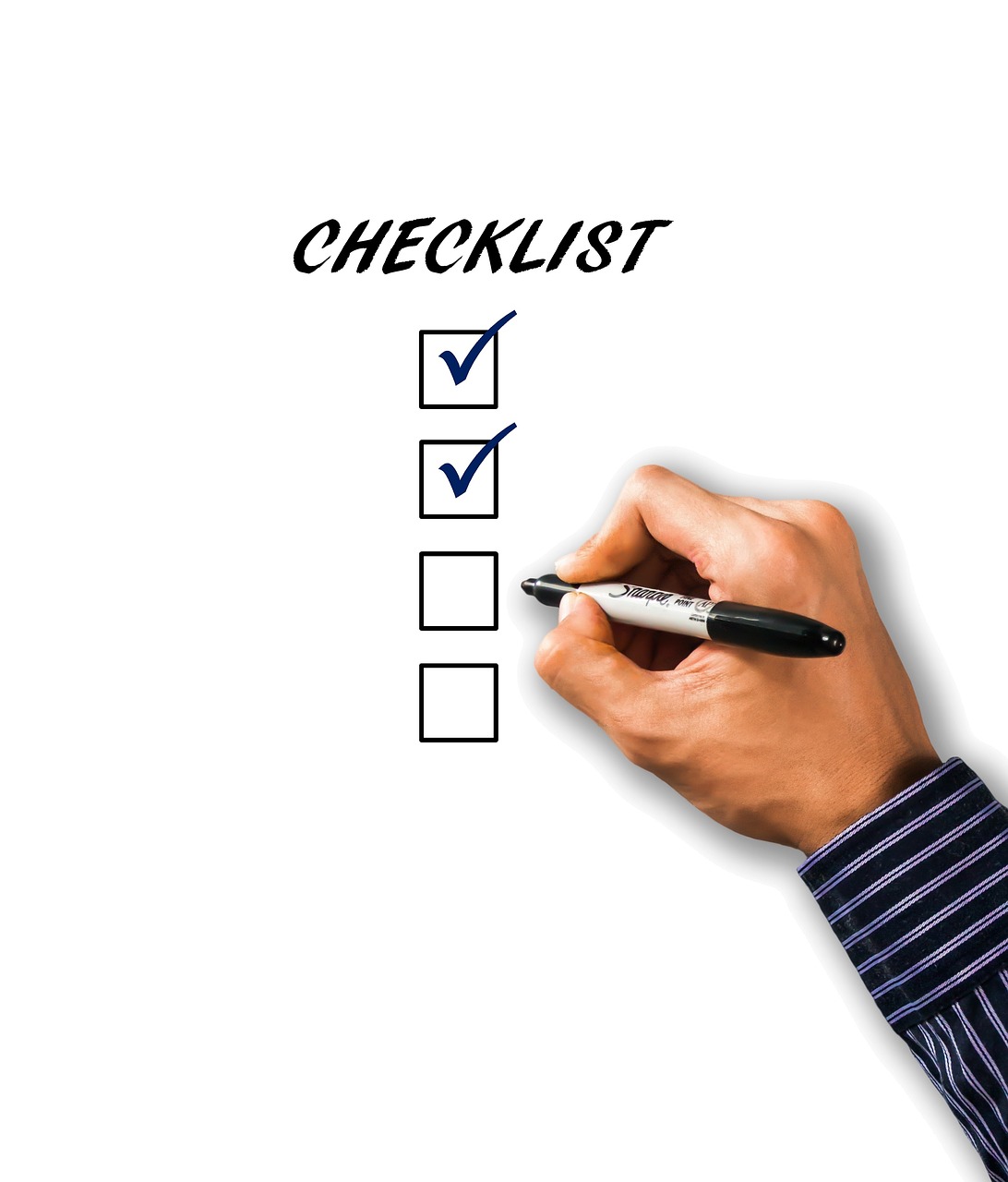 Hand checking off items on a checklist with a pen.