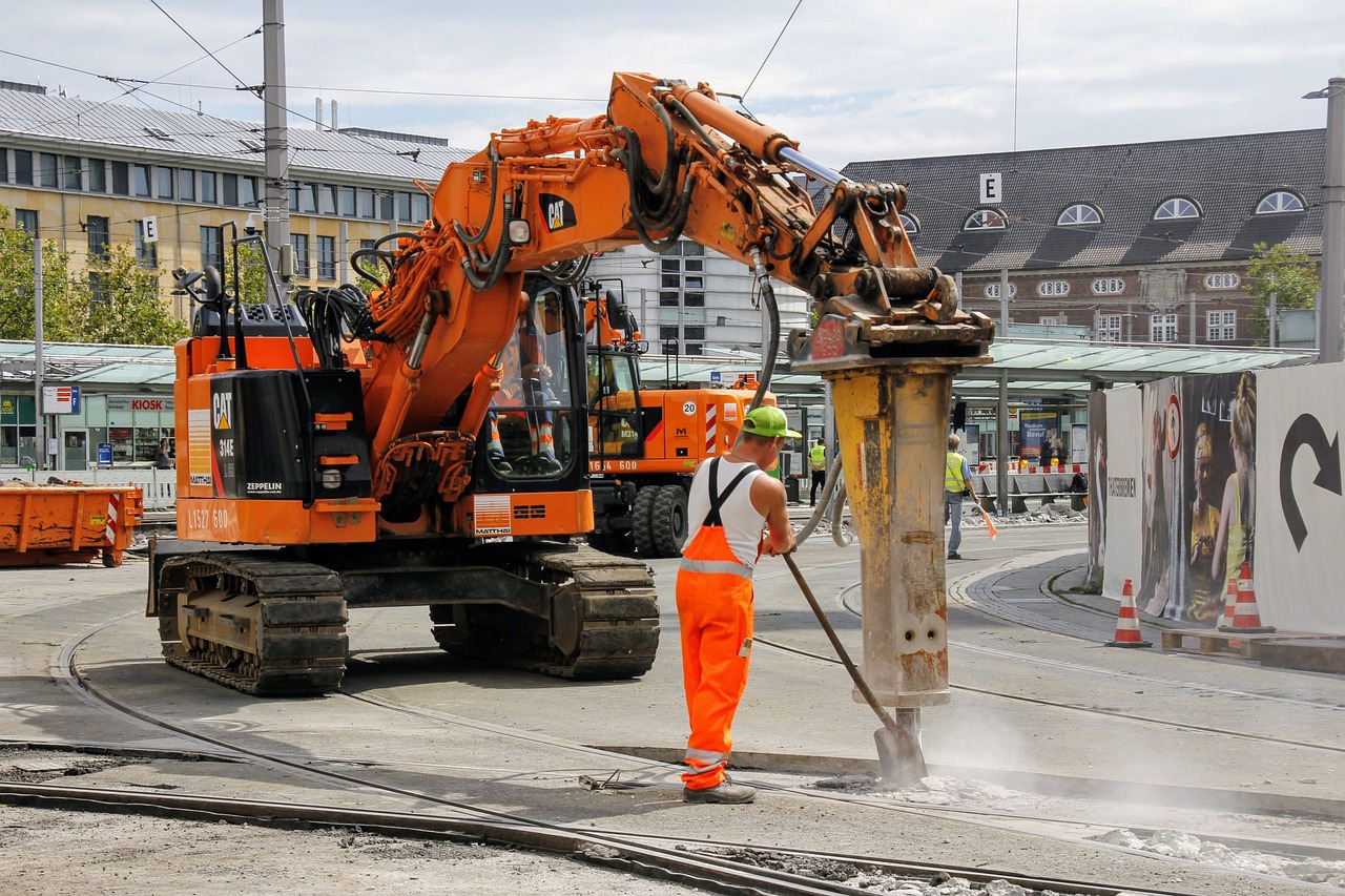 Construction worker monitors powerful concrete breaking equipment.