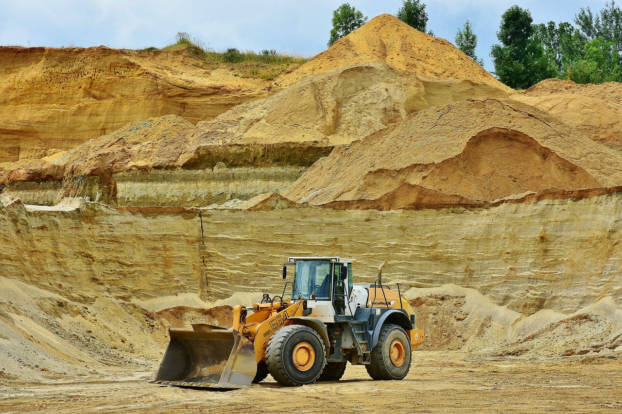 A bulldozer sits deep within a sprawling excavation site.