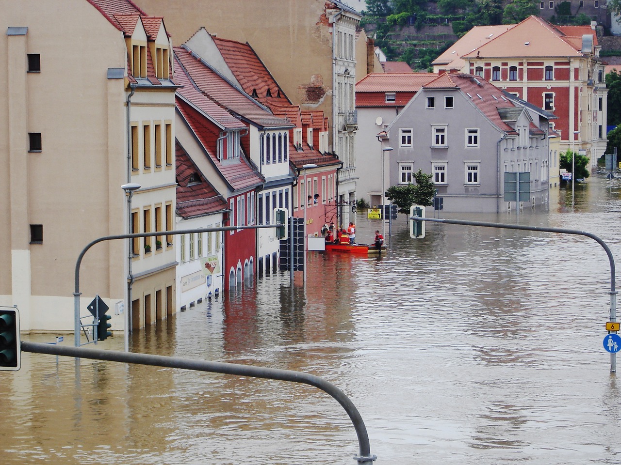 Floodwaters engulf streets and buildings in a mixed-use neighborhood.