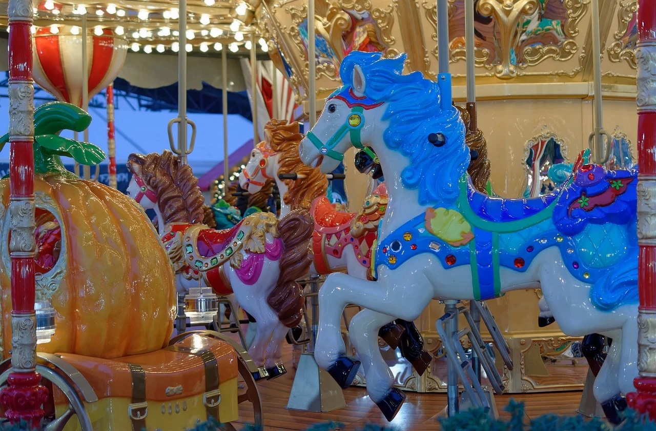 Colorful merry-go-round spinning at a bustling amusement center.