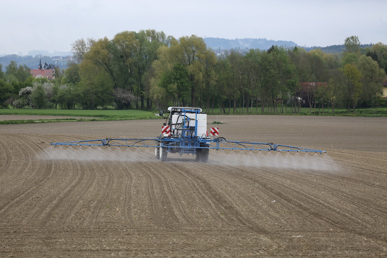 Tractor-mounted chemical sprayer in operation on a farm