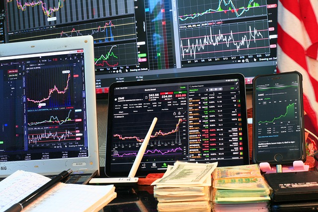 Screens display volatile market charts in busy financial consulting office.