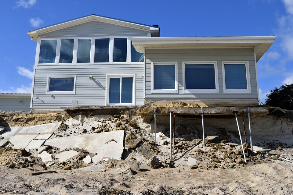 Flood-damaged home propped up on temporary supports.