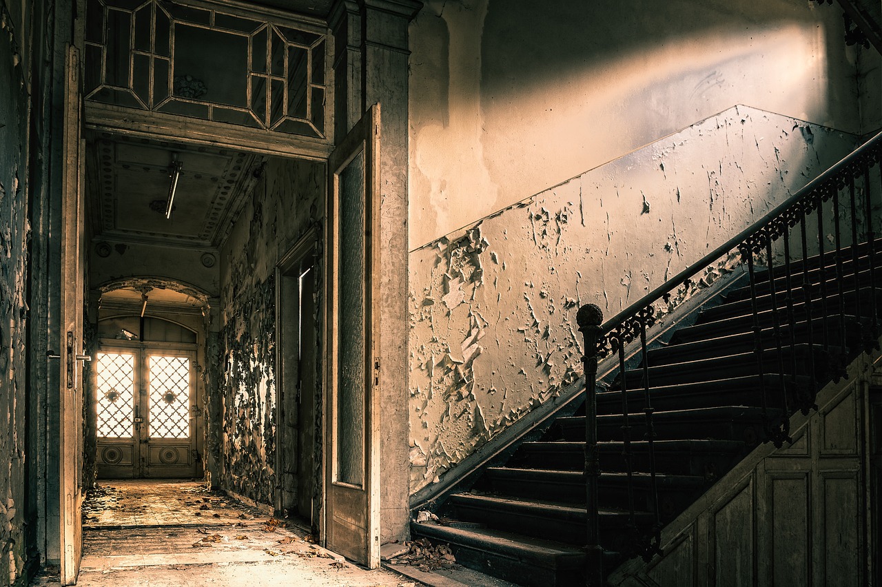 Water damage, peeling paint, and potential mold stains a once-white wall.