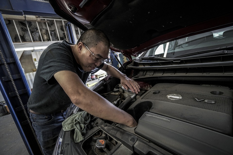  Technician inspecting semi-truck engine with hood open to ensure roadworthiness