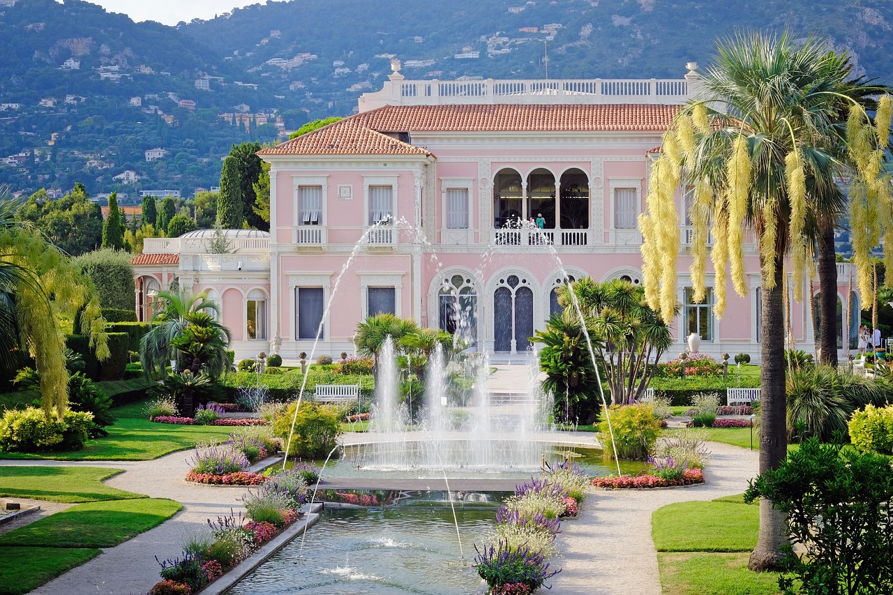 Exterior of a grand luxury residence with manicured lawns, ornate fountains, and sophisticated architecture.