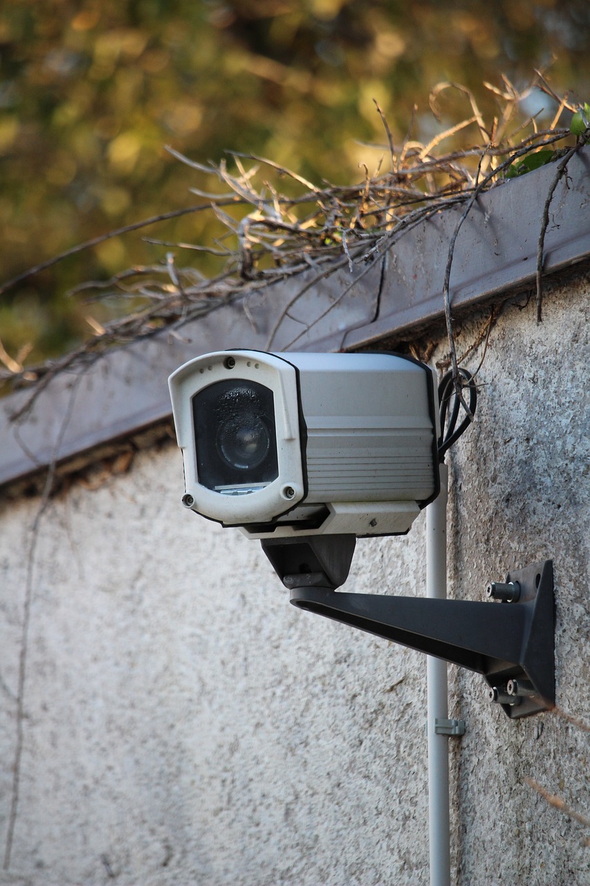 Close-up of a security camera mounted on a residential building wall.
