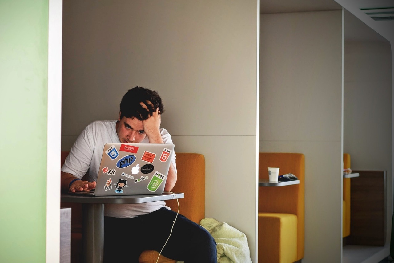 Frustrated client holding head, experiencing disappointment due to unmet expectations from marketing services.