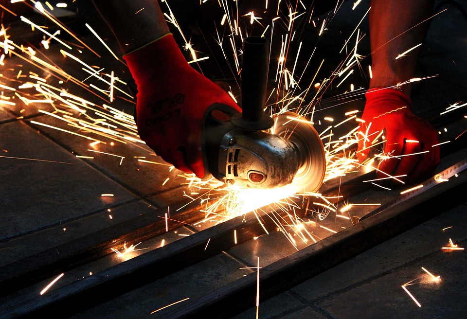 Sparks fly as skilled fabricator cuts and shape metal 