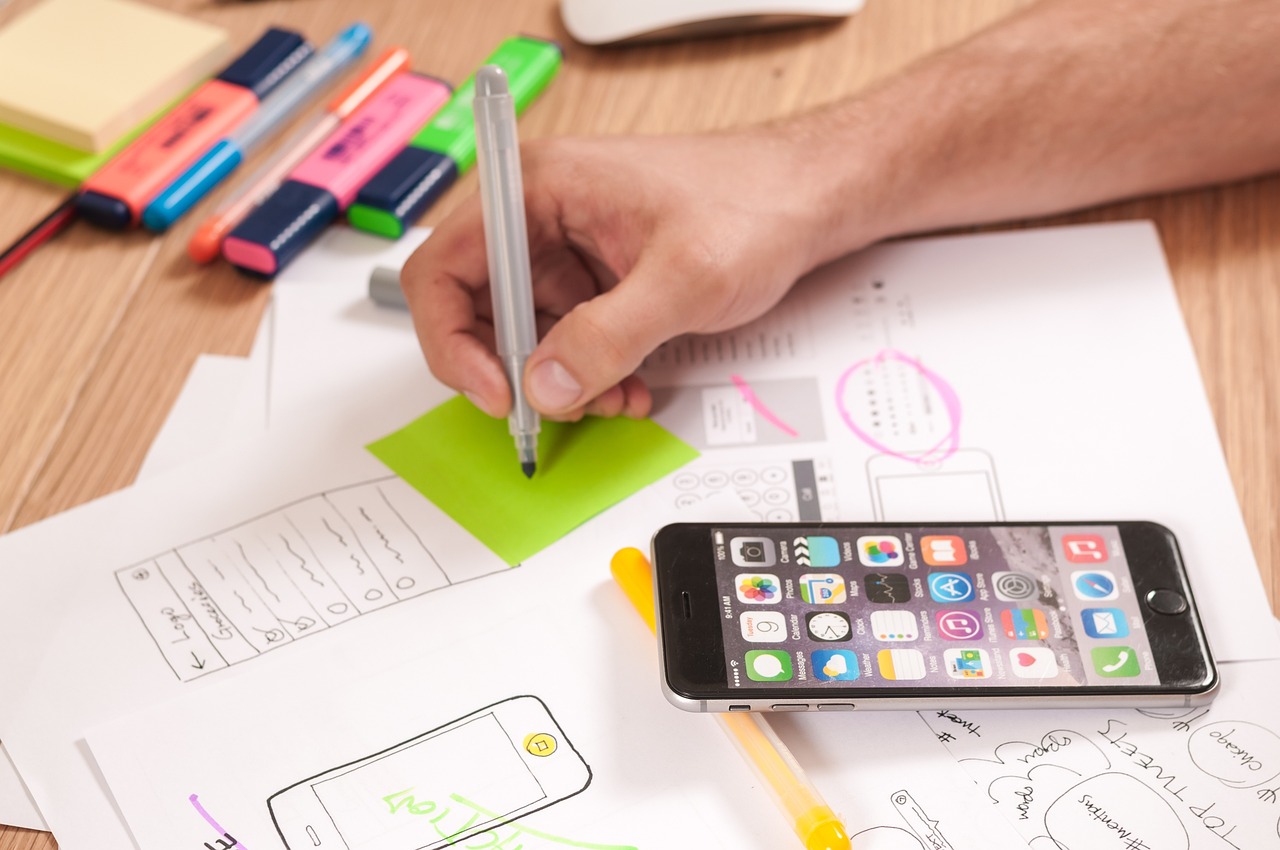 Web designer taking notes at desk