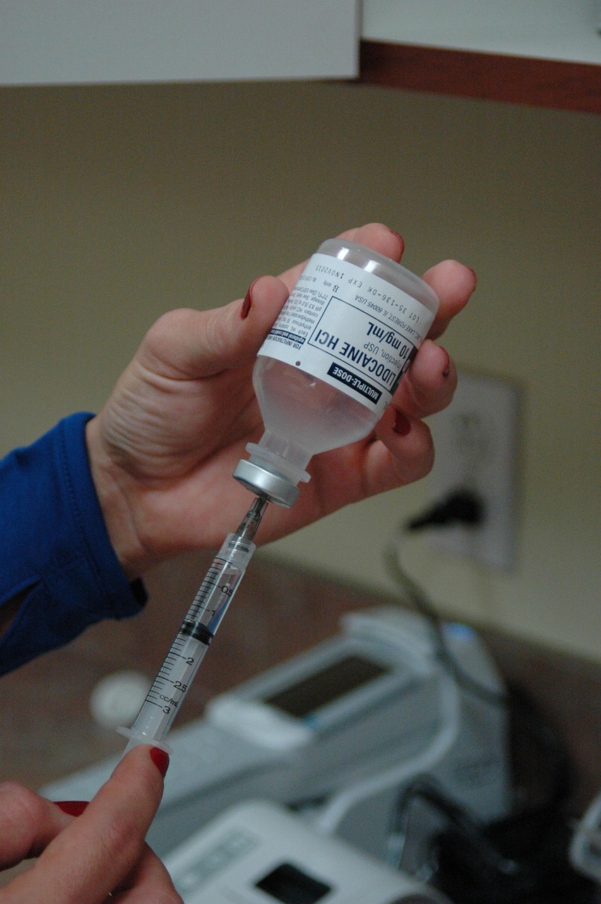 Nurse extracting prescribed dose from a vial.