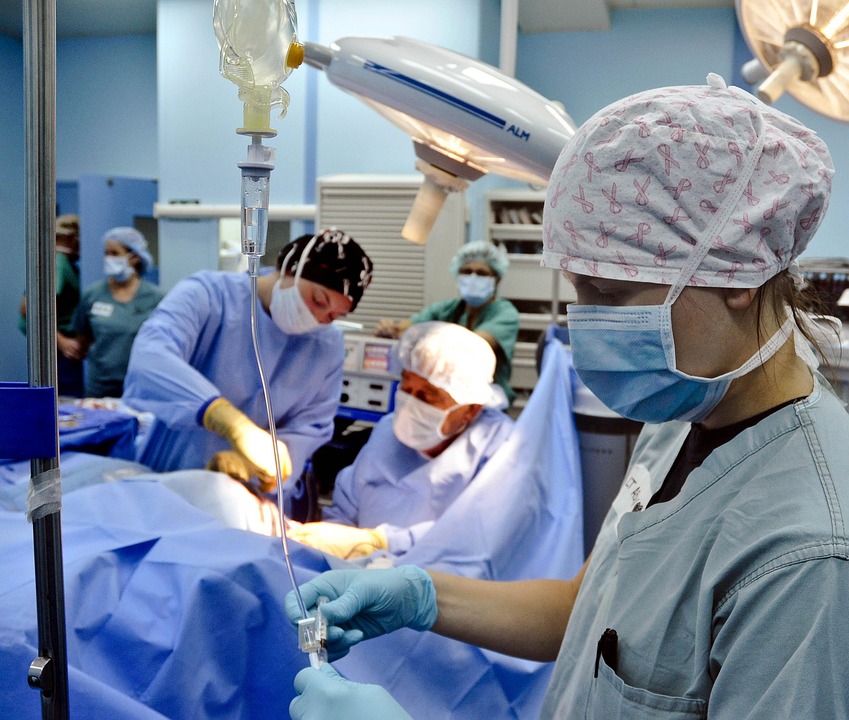 A travel nurse assists in an operating room