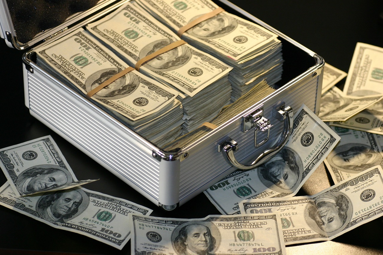 Cash box overflowing with dollar bills 